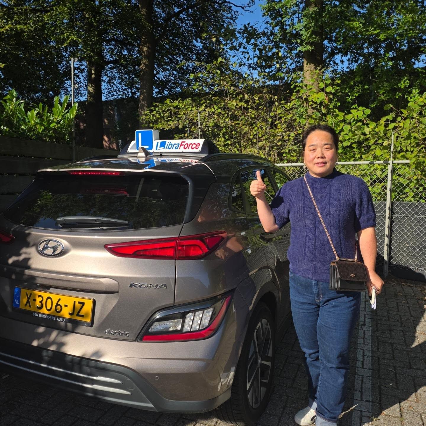 Geslaagde leerling van LibraForce bij de lesauto