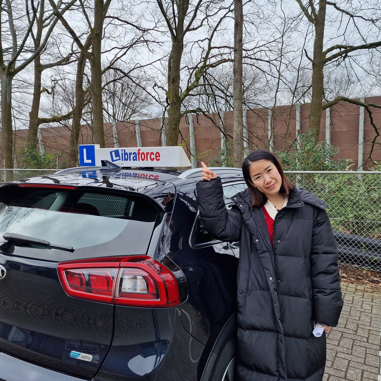 Geslaagde leerling van LibraForce bij de lesauto