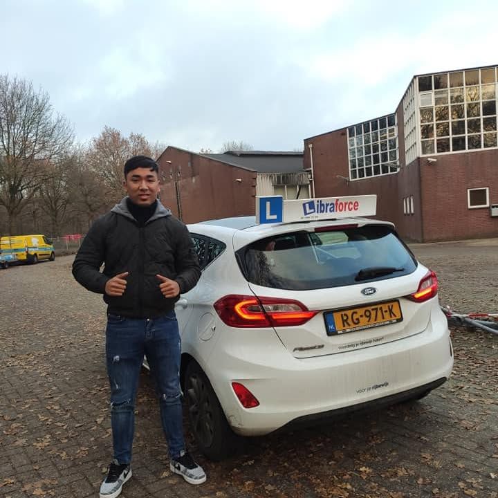 Geslaagde leerling van LibraForce bij de lesauto