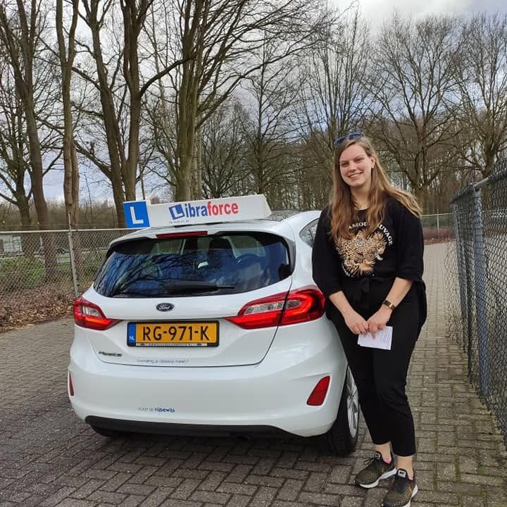 Geslaagde leerling van LibraForce bij de lesauto
