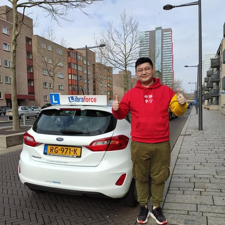 Geslaagde leerling van LibraForce bij de lesauto