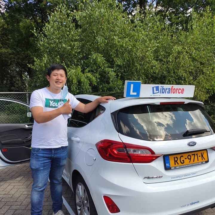 Geslaagde leerling van LibraForce bij de lesauto