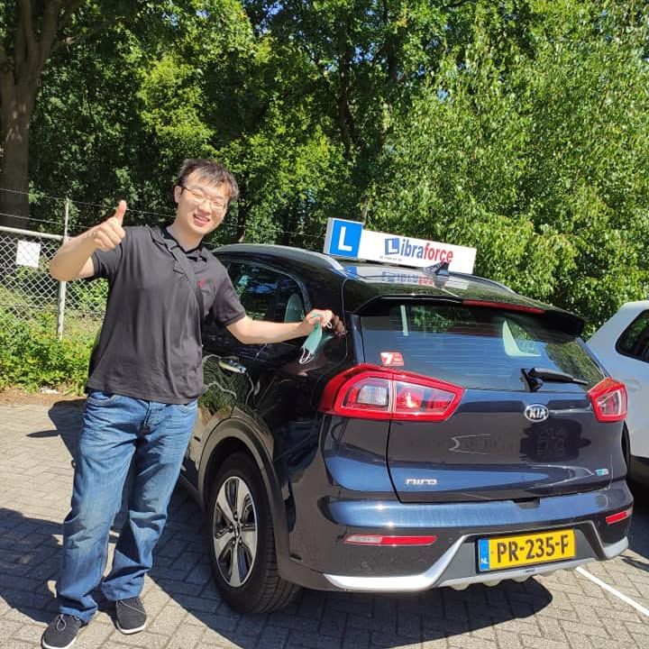 Geslaagde leerling van LibraForce bij de lesauto