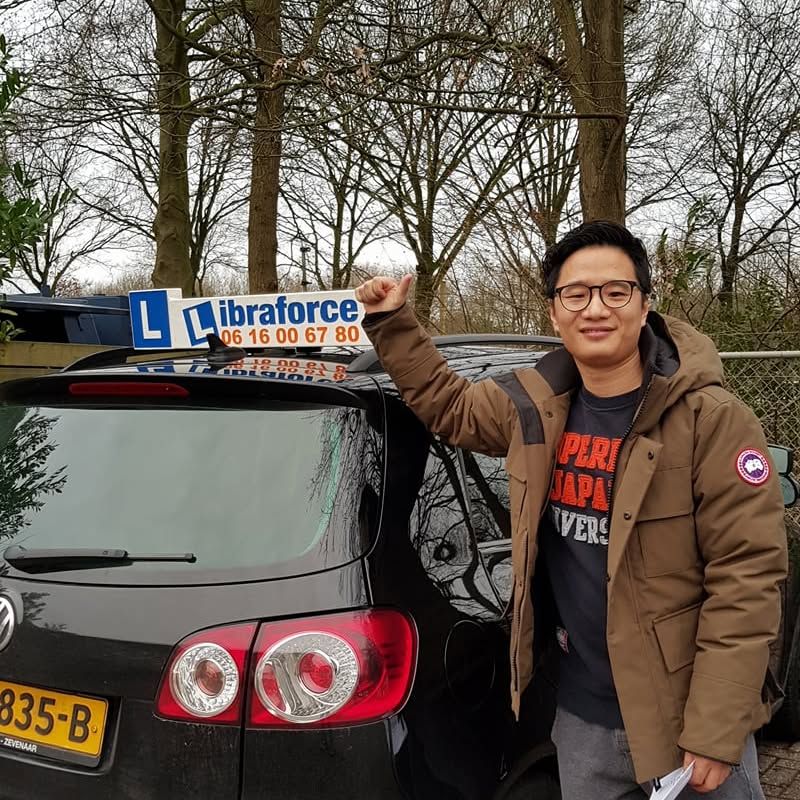 Geslaagde leerling van LibraForce bij de lesauto