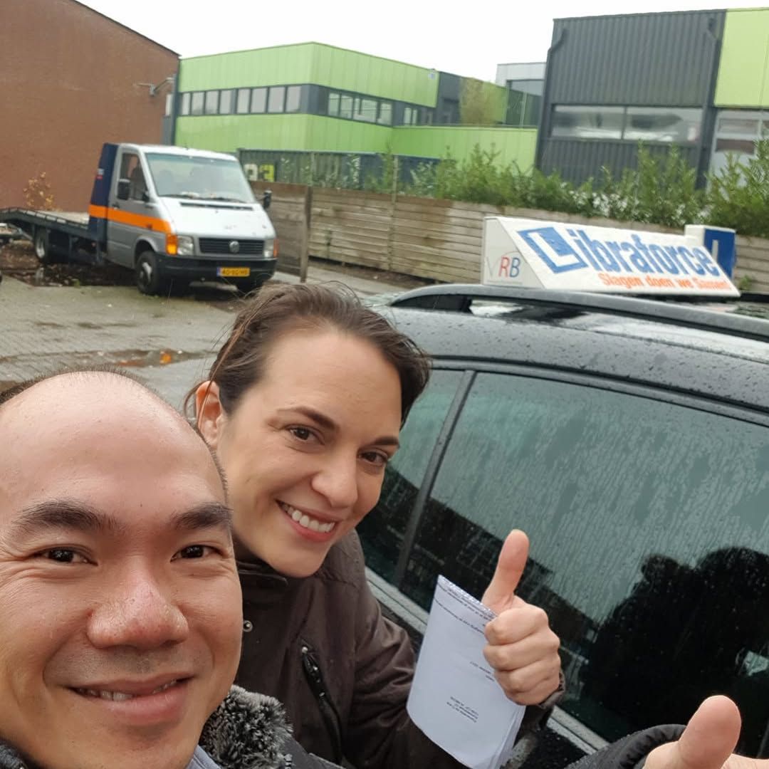 Josef van LibraForce met een geslaagde leerling voor de lesauto met het bord Slagen doen we Samen