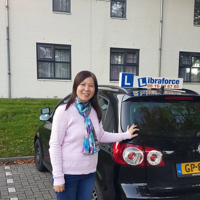 Geslaagde leerling van LibraForce bij de lesauto