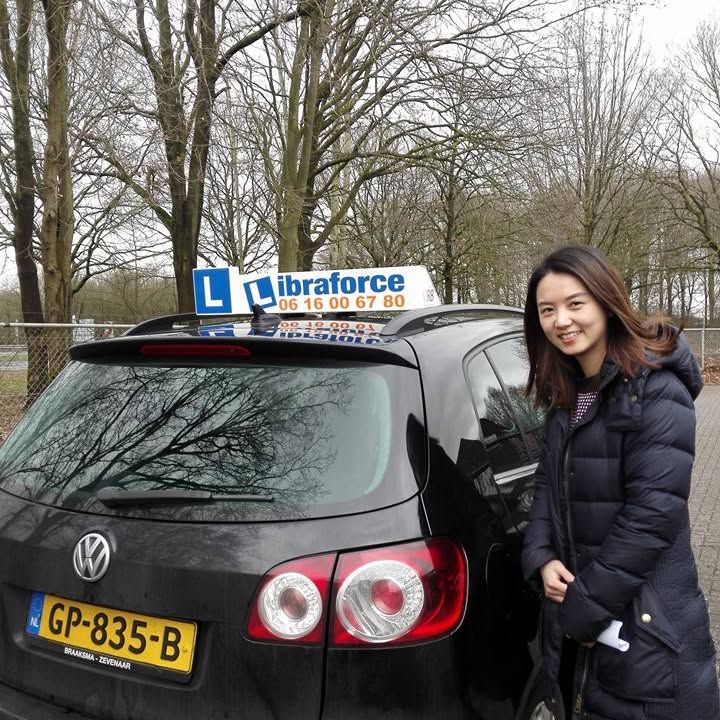Geslaagde leerling van LibraForce bij de lesauto