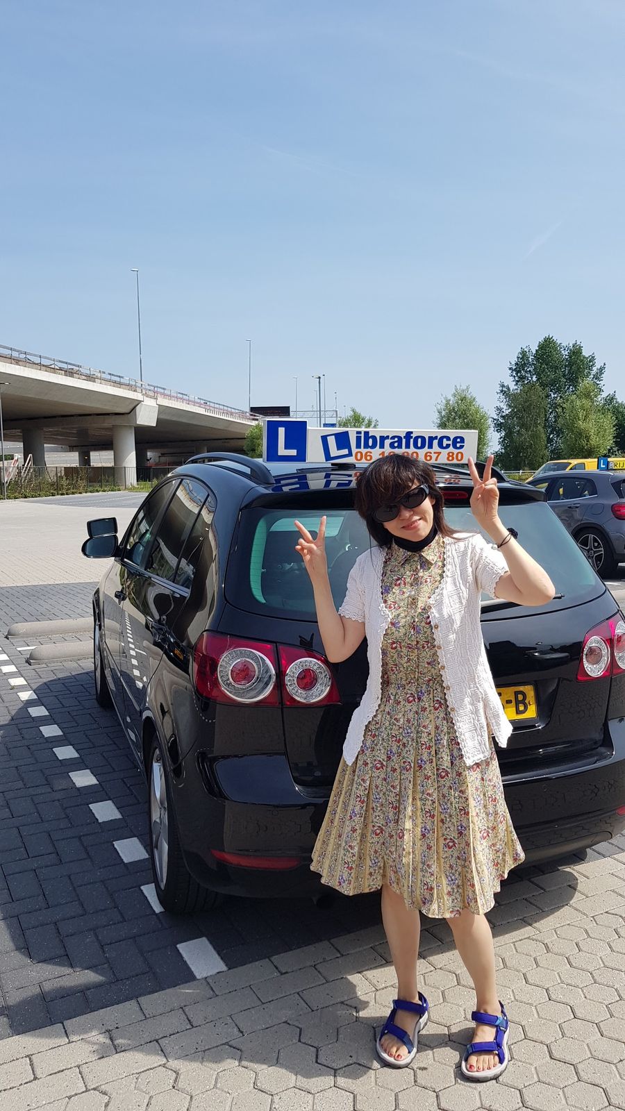 Geslaagde leerling bij de zwarte lesauto van LibraForce